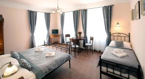um quarto de hotel com duas camas, uma mesa e cadeiras em Penzion Na 15. Poledníku em Jindřichŭv Hradec mais 35 fotografias