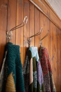 drei Handtücher hängen an einer Holzwand in der Unterkunft Casa Fratomari - The Alpine dream in Lombro