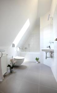 um banheiro branco com uma pia e uma banheira em Penzion Na 15. Poledníku em Jindřichŭv Hradec