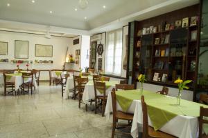 a restaurant with tables and chairs with green table cloth at Hotel La Tripergola in Pozzuoli