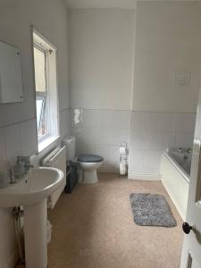 a bathroom with a sink and a toilet and a tub at Modern Double Rooms Near Stoke City Centre and Staffordshire Uni in Stoke on Trent +4 photos