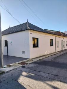 a white building with black windows on a street at Costa Home in Gafanha da Nazaré
