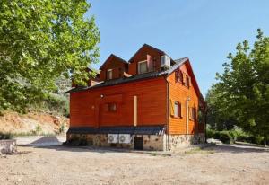 a large wooden house sitting on top of a field at Casa de madera El Vado in Villanueva del Arzobispo