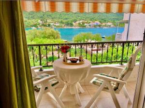un tavolo e sedie su un balcone con vista di Apartments Neve a Grebaštica