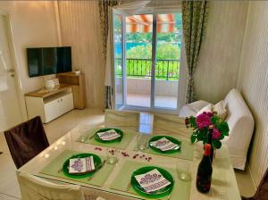 un tavolo da pranzo con un vaso di fiori sopra di Apartments Neve a Grebaštica