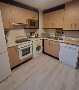 a kitchen with white appliances and wooden cabinets at Casa los Rebecos in Villanúa