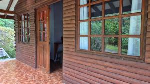 Casa de madera con puerta y ventanas en Cabañas La Catarata, en Higueronal