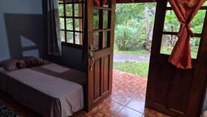 Un dormitorio con una cama y una puerta abierta. en Cabañas La Catarata, en Higueronal 7 fotos más