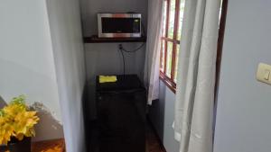 una habitación con un microondas en un estante junto a una ventana en Cabañas La Catarata, en Higueronal