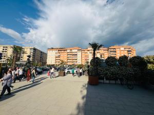 a group of people walking on a sidewalk in a city at Rubinas Apartment in Prizren