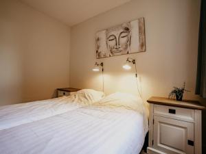 Un dormitorio con una cama blanca y dos lámparas. en Apartment in Netherlands near Amsterdam, en Uitgeest
