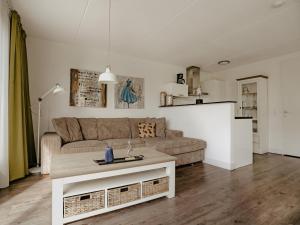 una sala de estar con un sofá y una mesa en Spacious Lakeside Retreat, en Uitgeest
