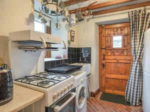 a kitchen with a stove and a sink at The Cowshed in Penrith