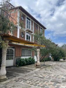 a brick building with an arbor in front of it at Hotel Quinta Los Nogales in Tlalpujahua de Rayón