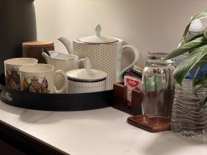 マックルズフィールドにあるPrivate King Room - Near AZ and Train Linksのたくさんのカップと花瓶が置かれた棚