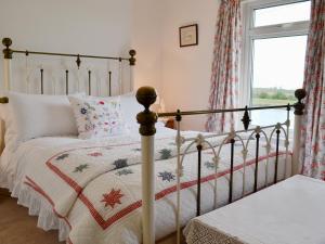 een slaapkamer met een bed en een raam bij Greenbank Cottage in Hilgay