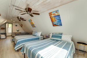 2 camas en una habitación con ventilador de techo en Dock and Bar A-Frame Retreat on Cedar Creek Lake!, en Tool