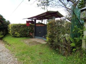 a shed with a gate in a yard at Finca la Albania in Circasia