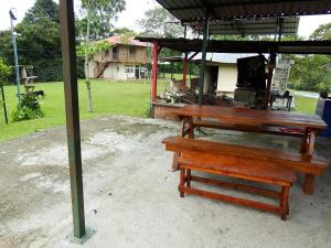 a picnic table and a bench under a pavilion at Finca la Albania in Circasia +4 photos