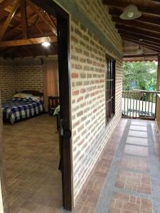 a room with a brick wall and a bedroom at Finca la Albania in Circasia