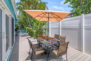 a patio with a table and chairs and an umbrella at Toes in the Sand - 113 in Sarasota