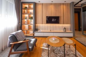 a living room with a chair and a table at Modern Mountain - Comfort Apartment in Kolašin