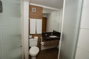 a bathroom with a toilet and a sink at Orion Inn Hotel in Itumbiara +36 photos