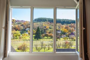 a window with a view of the fall foliage at Modern Mountain - Comfort Apartment in Kolašin