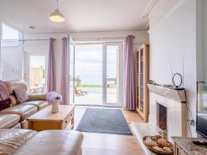 ein Wohnzimmer mit Couch und Kamin in der Unterkunft Beachside, West Yardley House - Uk31200 in Downderry