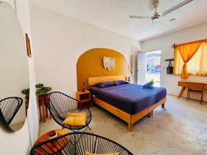 a bedroom with a bed and two chairs at Costa Rentals Palmar & Wasi in Brisas de Zicatela