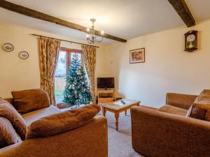a living room with a christmas tree and a couch at Rafters Barn - E2064A in Runcton Holme