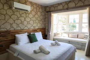 a bedroom with two beds and two windows at naya port in Alacati +105 photos