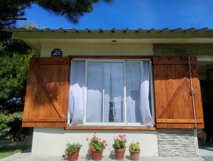 a house with wooden doors and potted plants at Casa Tiale - Chapadmalal , Campo y Olas- in Colonia Chapadmalal