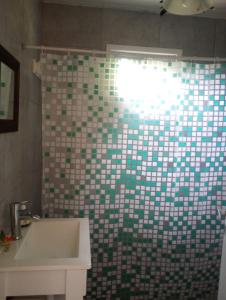 a bathroom with a green and white tiled wall at Casa Tiale - Chapadmalal , Campo y Olas- in Colonia Chapadmalal +21 photos