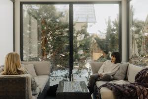 two women sitting on a couch in a living room at BURSZTYNOWA-PRZYSTAŃ in Lubiatowo +87 photos