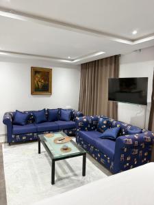 a living room with blue couches and a table at Port la goulette in La Goulette