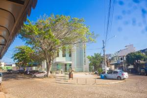 a street with cars parked in front of a building at Pousada Panceiro in Cabo Frio