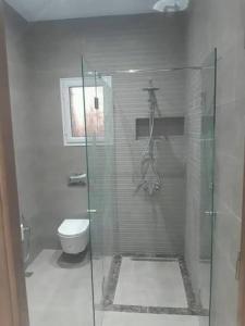 a bathroom with a glass shower and a toilet at Port la goulette in La Goulette