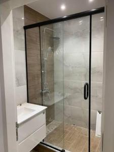 a bathroom with a glass shower and a sink at Port la goulette in La Goulette