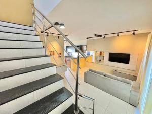 eine Treppe in einem Haus mit einem Fernseher an der Wand in der Unterkunft Casa com 2 suites em condomínio no Frances in Marechal Deodoro
