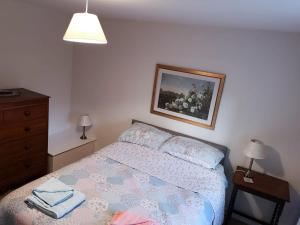 ein Schlafzimmer mit einem Bett und einem Bild an der Wand in der Unterkunft Beck Cottage in Colby + 5 Fotos