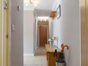 a hallway with a kitchen with a vase of flowers at Lavender Cottage Was Fellside in Melmerby