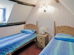 1 Schlafzimmer mit 2 Betten und einem Nachttisch in der Unterkunft Sharrowhead Cottage - E4044 in Robin Hood's Bay