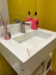 Un lavabo con dos botellas encima. en Praia Grande Aviação Apto Disney, en Praia Grande