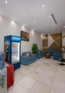 a lobby with blue couches and a soda machine at فندق رفاق مكة in Makkah