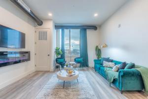 un salon avec un canapé bleu et une table dans l'établissement Emerald Escape, Free Parking, 2 Bath, Sleeps 8 Near American Dream and The Airport, King Bed and 2 Queen Beds, Washer and Dryer, à Orange