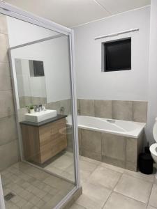 een badkamer met een bad, een wastafel en een toilet bij Elevare suites in Nelspruit