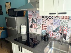 a kitchen with a sink and a refrigerator at Jaky Maison Torino, Cozy & Modern Stay in Turin