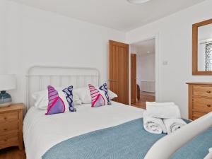 ein weißes Schlafzimmer mit einem weißen Bett und Kissen in der Unterkunft The Keys - Cottage in Sardis