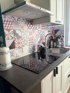 a kitchen with a sink and a tile wall at Jaky Maison Torino, Cozy & Modern Stay in Turin